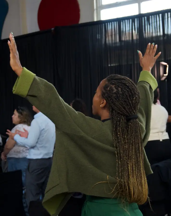 A woman worshipping with hands raised