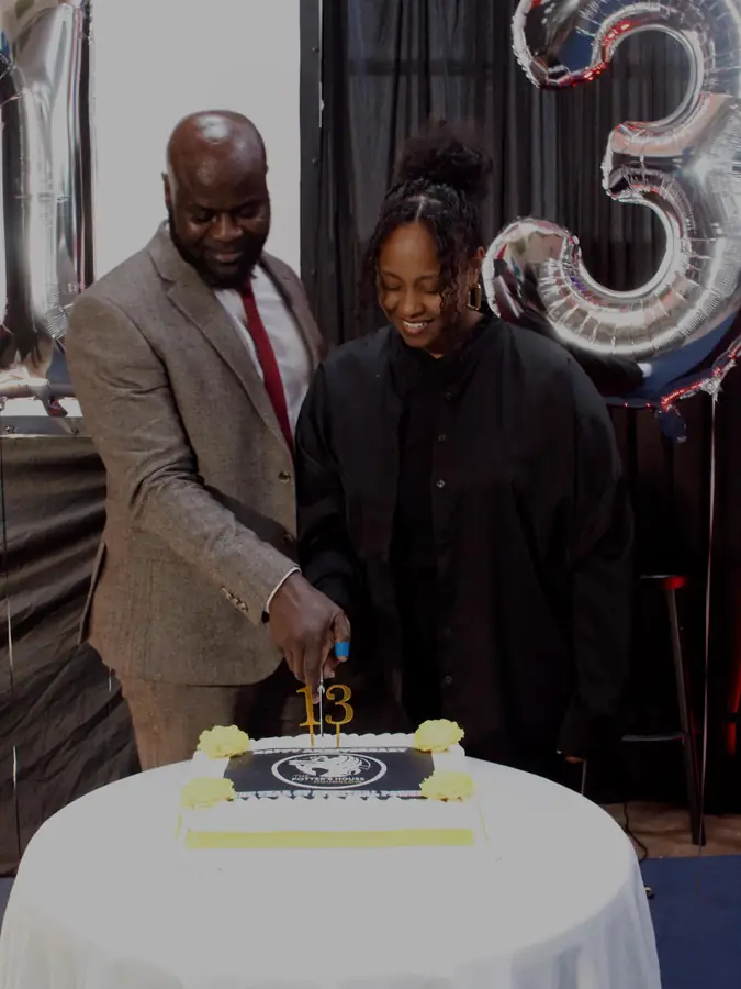 The pastor and a young woman cutting a celebration cake