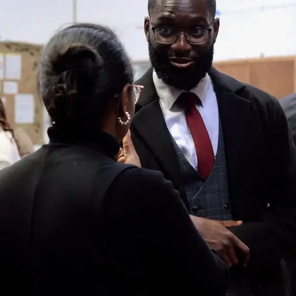 A man in a suit talking with a church member